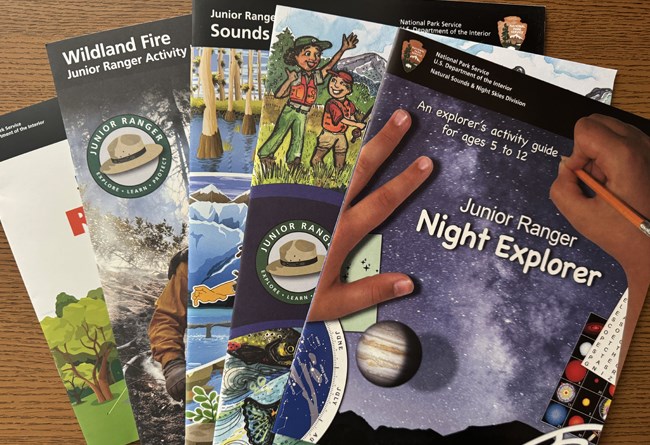 Jr Ranger booklets spread out on table.