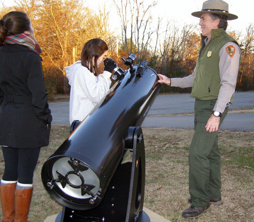 Visitors viewing telescope with park ranger