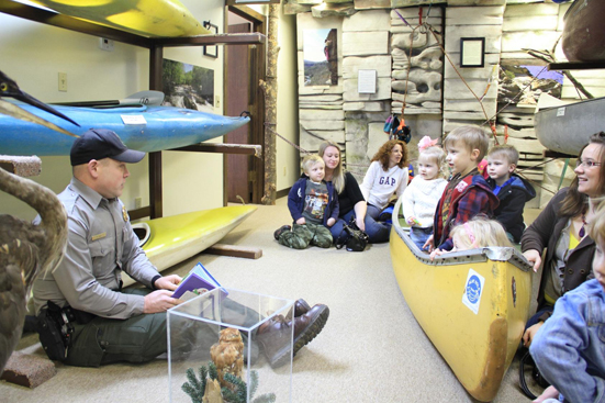 Park Ranger telling a story to a group of kids inside the visitor center