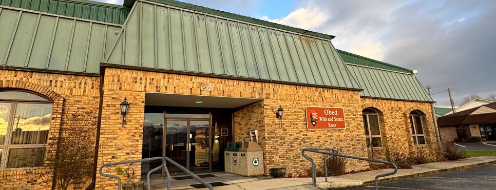 Brick building with green roof and a sign that says Obed Wild and Scenic River