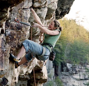 girl climbing up the side of a mountain