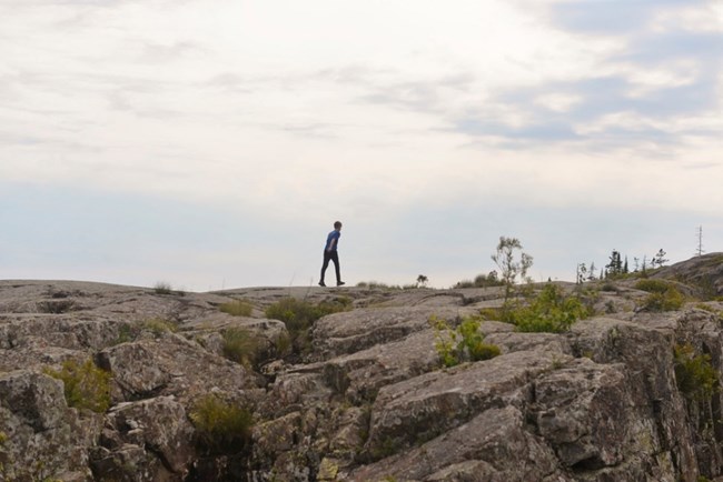 child walking atop rocky trail