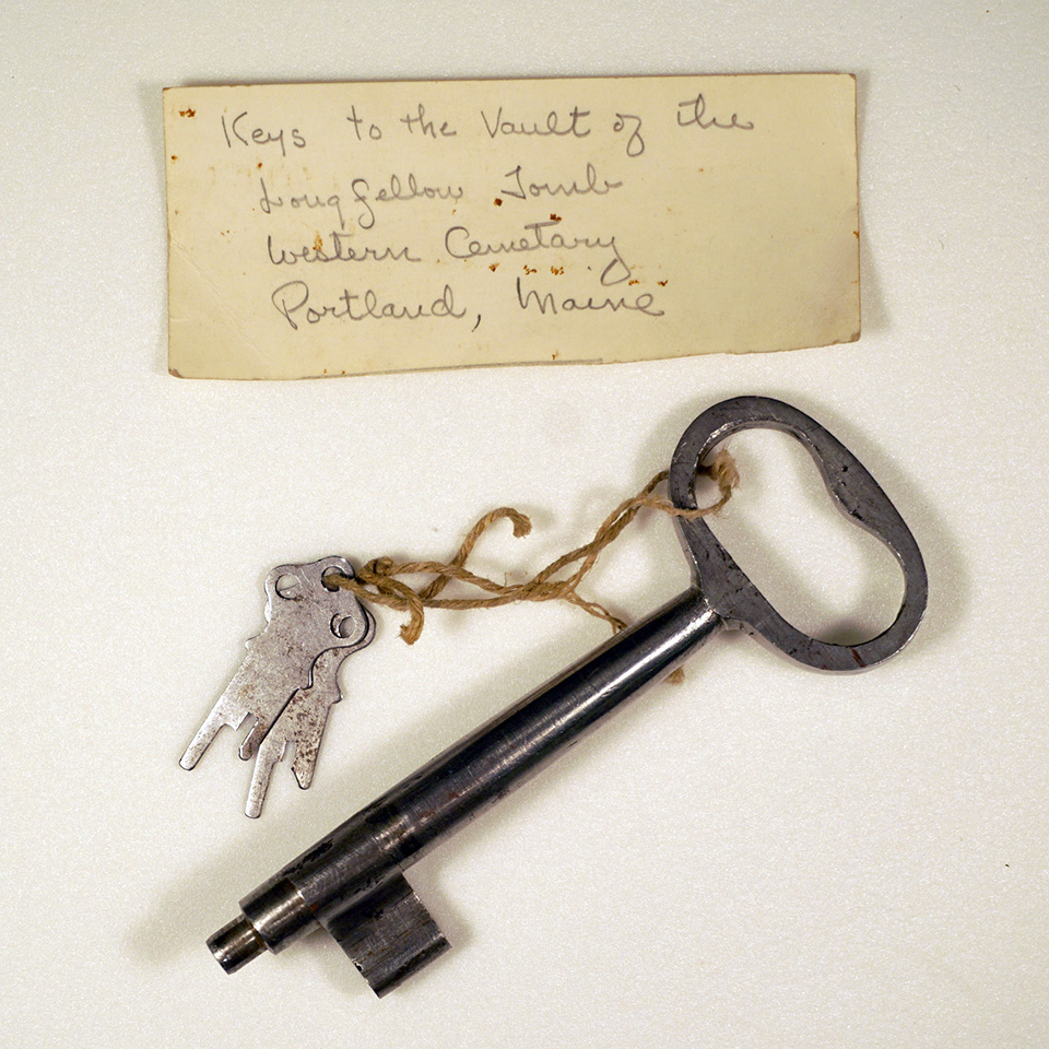The key to the Longfellow family tomb in the Western Cemetery in Portland, Maine. A large metal key to a cemetery tomb along with two smaller keys and a handwritten note.