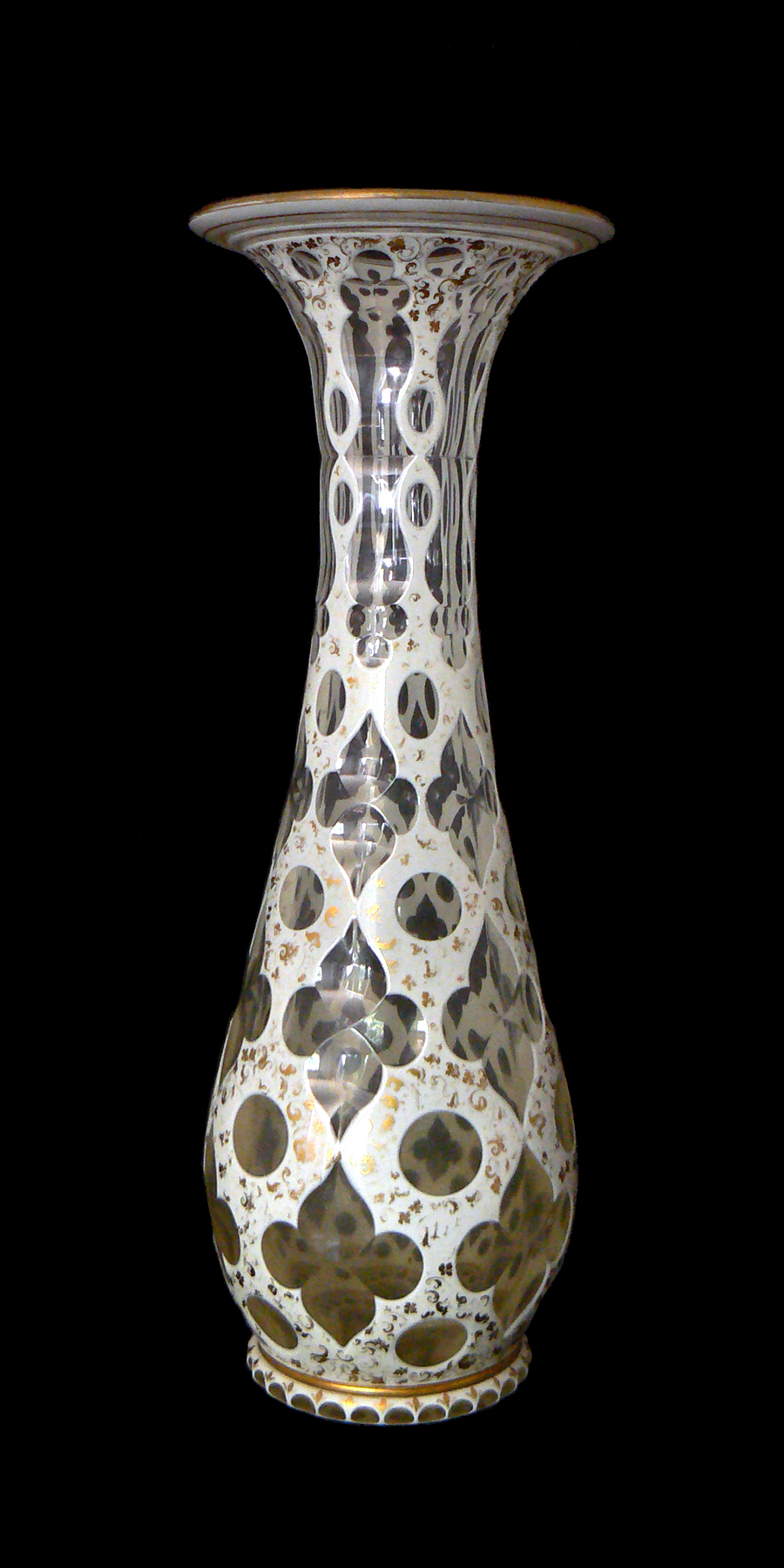 A tall clear and white glass vase with flared lip and incised decoration.