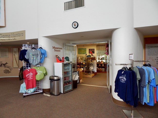 A view of the store entrance, with a cooler of drink and small merchandise outside.