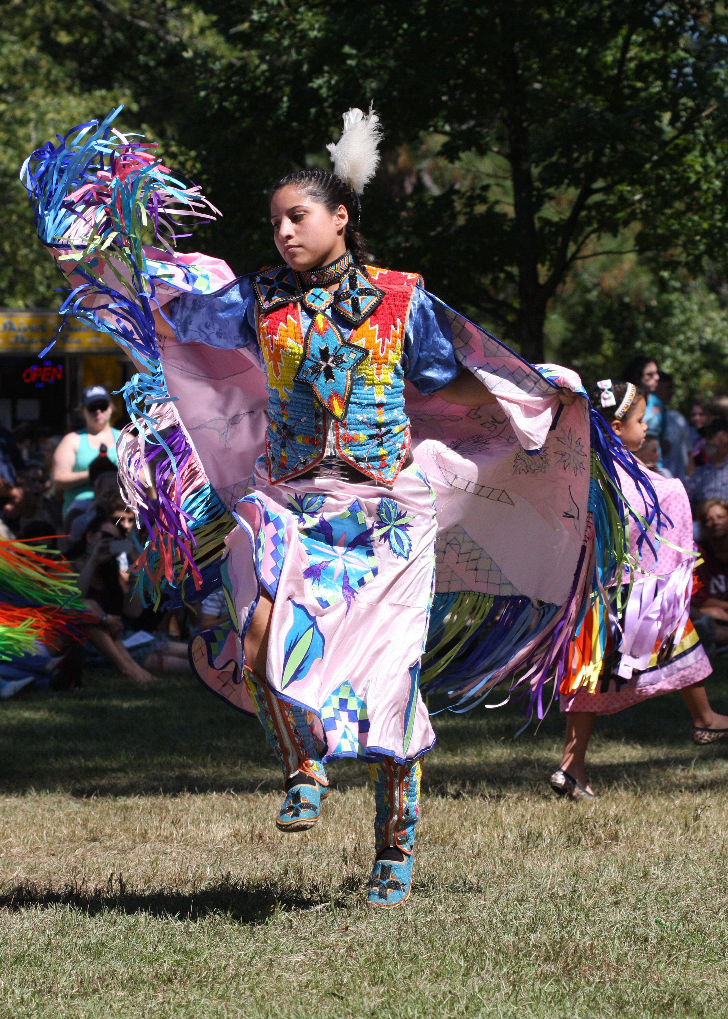 a shawl dancer in pink dress dancing at the event