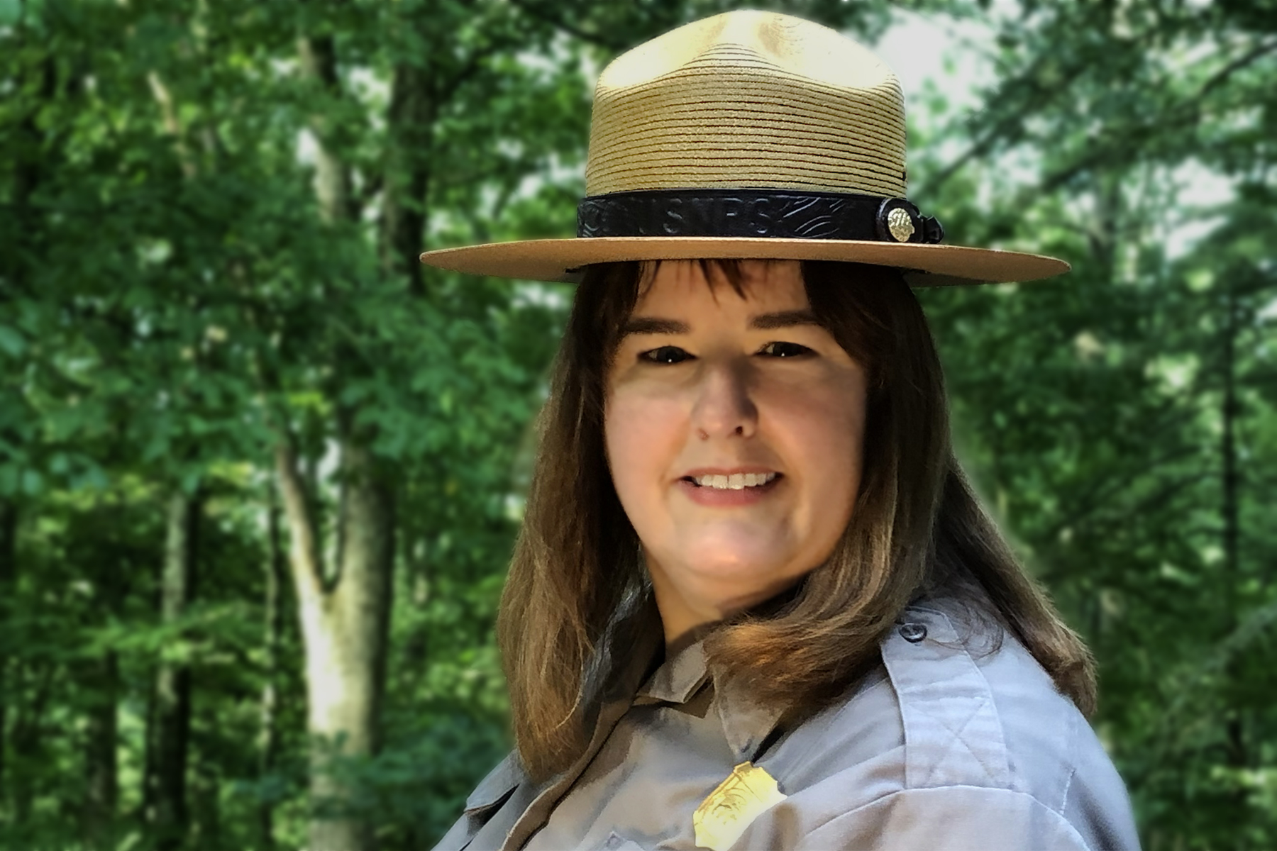 Ocmulgee Mounds National Historical Park Superintendent Carla Beasley Woman in broad-brimmed hat stands smiling in front of a tree.