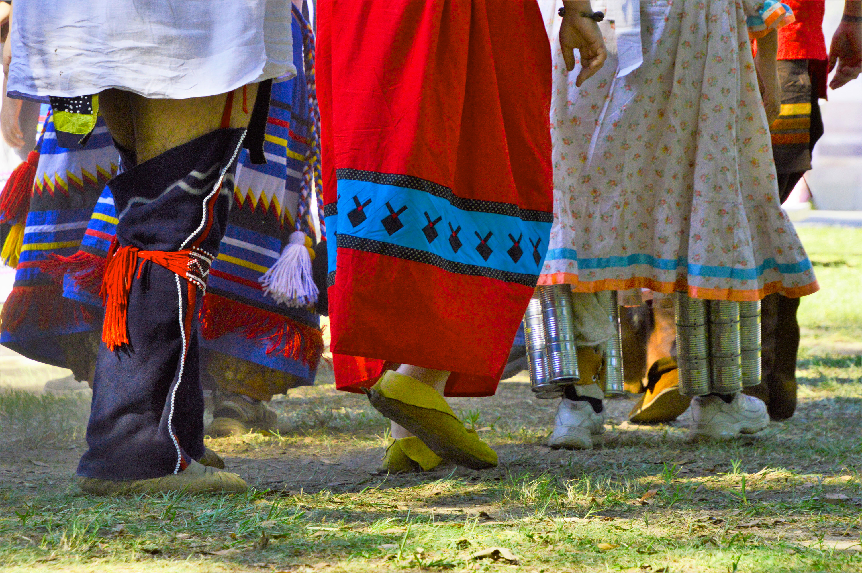 Stomp Dance dancers in traditional attire; image focused on legs and feet