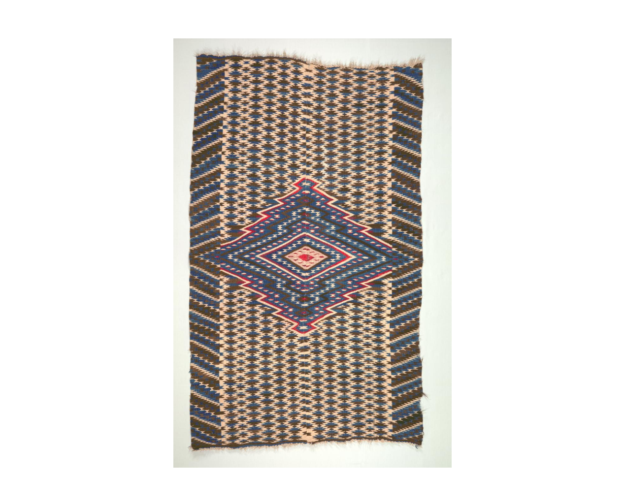 Example of Saltillo Style Blanket with an intricate blue and red diamond pattern.