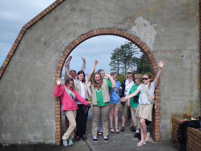Girl Scouts pose under arch at Kalaloch Beach