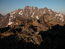 A view of a mountain ridge in the distance, as seen from the top of a separate mountain ridge.