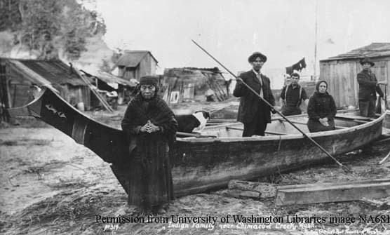 Historic photo of the Hicks family standing in and around a dugout canoe