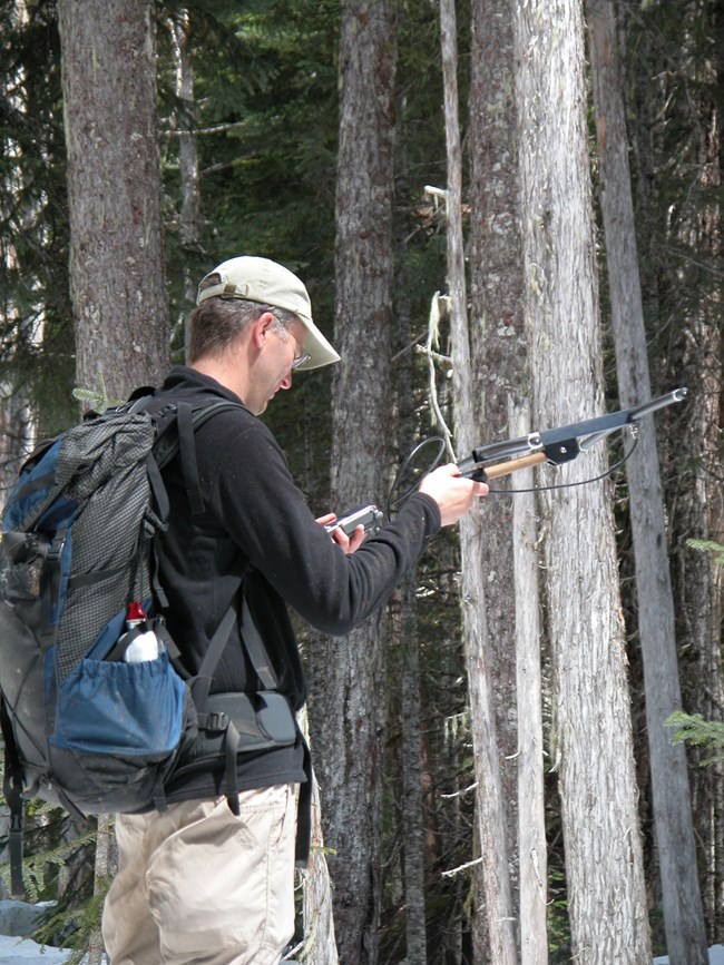 A man uses a radio antennae to track fisher.