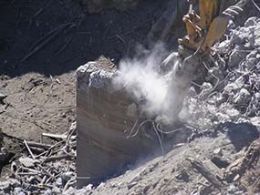 A hydraulic hammer chips away at the intake tower at Glines Canyon Dam.