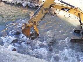 Excavator lifting rock
