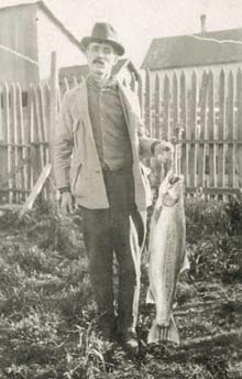 Historic photo of a man holding a salmon from the Elwha River Historic photo of a man holding a salmon from the Elwha River