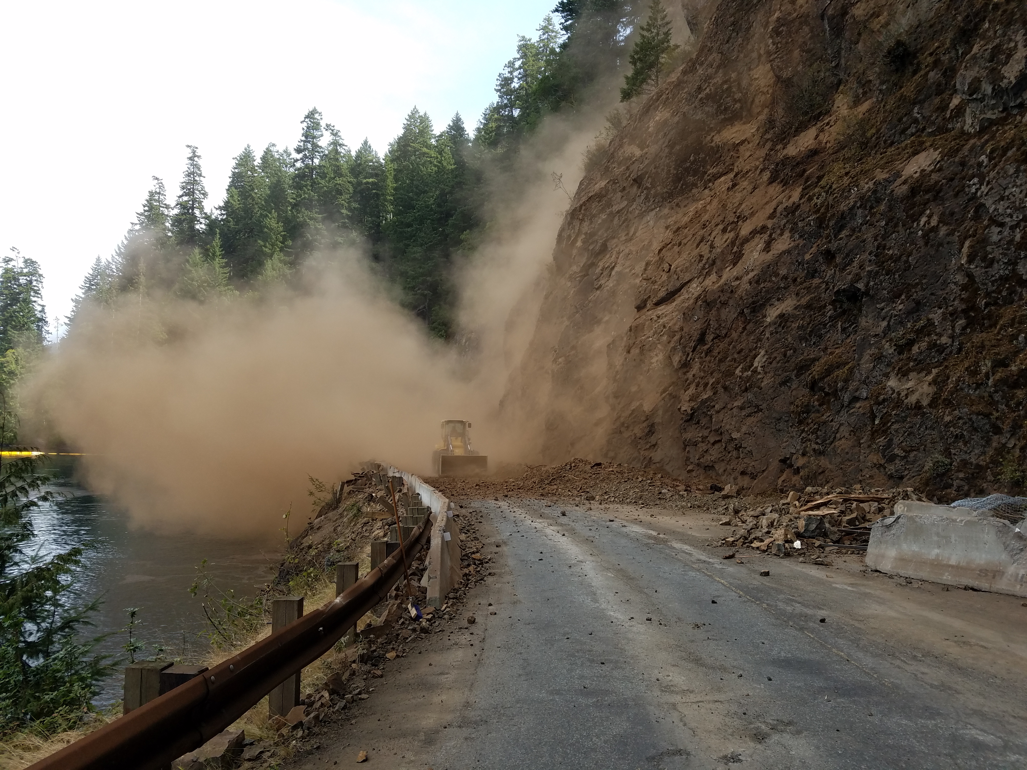 Front loader clearing debris after rock scaling work