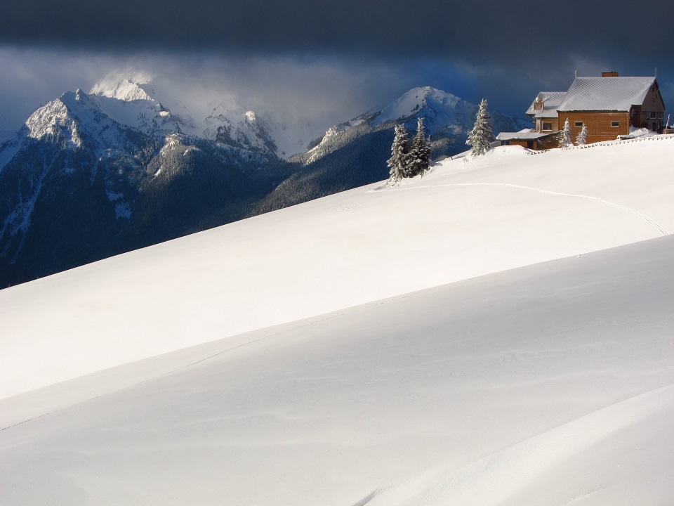 The Hurricane Ridge Day Lodge sits in a snow-covered landscape during wintertime.