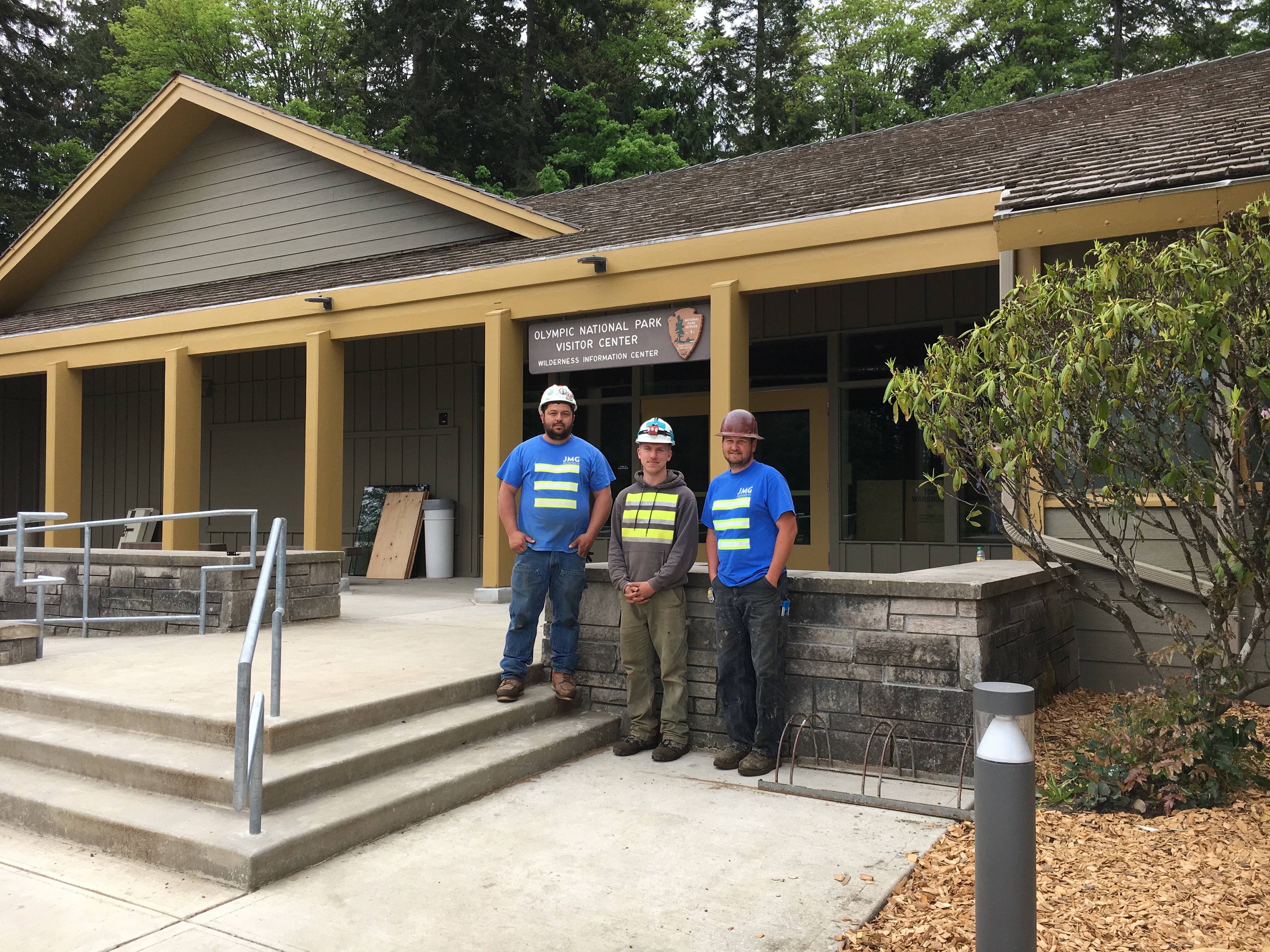 Construction workers standing in front of renovated visitor center