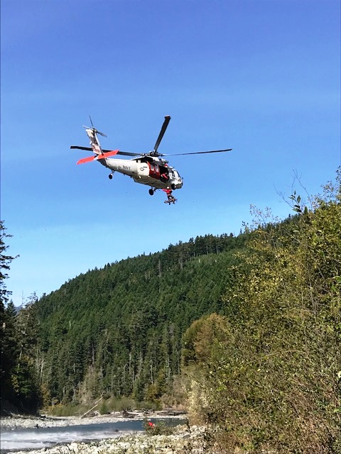 Navy helicopter performing a hoist operation for an injured backpacker. Helicopter hoisting a patient