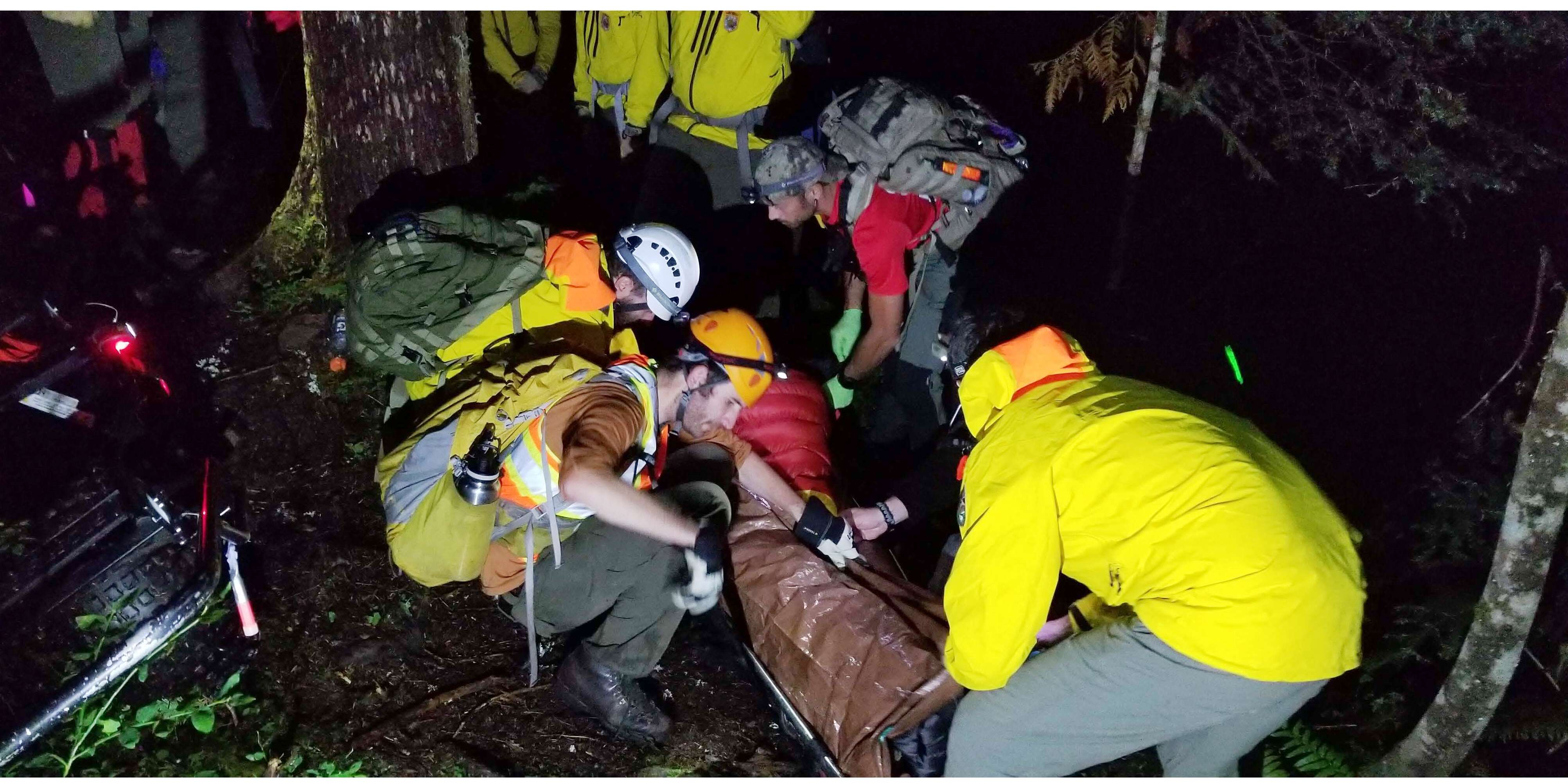 Rescue team preparing patient for litter carryout on Little River Trail. Rescue workers preparing a patient on a litter.