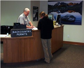 uniformed ranger talking with female visitor