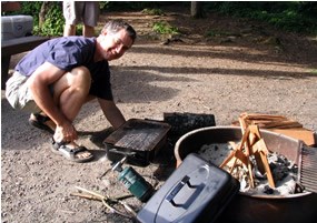 man and campground fire pit