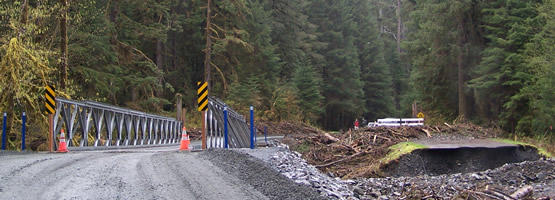gravel road leading to one-lane bridge