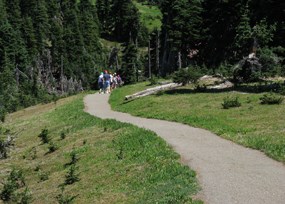 Hikers walk a paved trail at Hurricane Ridge
