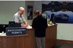 man helps woman at information desk