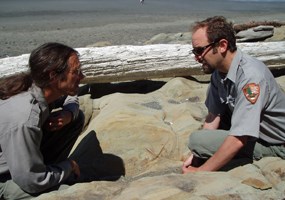 two men on either side of rock containing fossil seastar