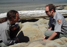 two men on either side of rock containing fossil seastar two men on either side of rock containing fossil seastar