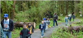 people walking through woods on paved trail
