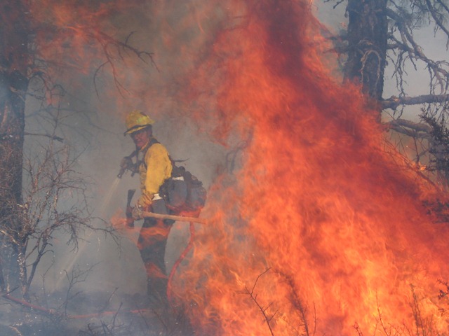 Firefighter cooling the flames