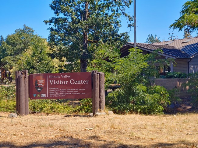 Illinois Valley Visitor Center sign in front of the building during the summer.