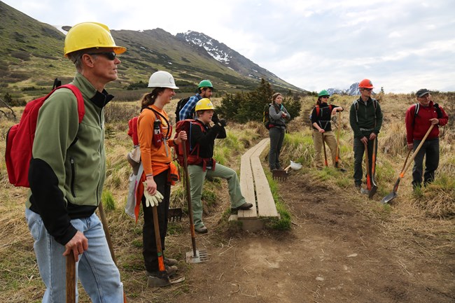 Volunteers listening to a trail crew leader.