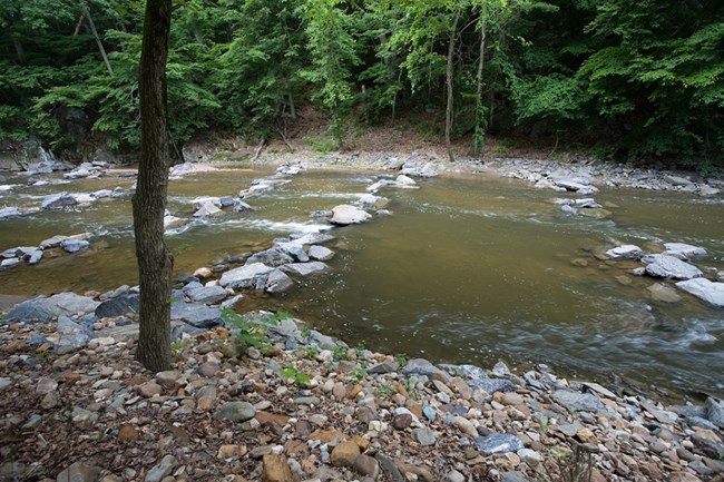 Rock Creek Stream Remediation Rock Creek stream flows over several bands of rocks protecting buried infrastructure.