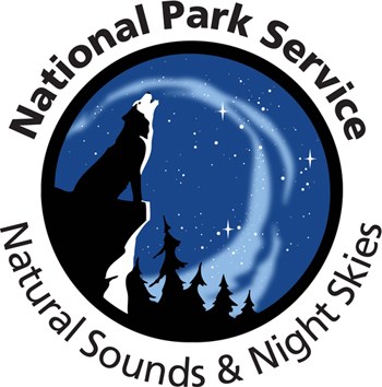Natural Sounds and Night Skies Division logo features an illustration of a howling wolf under a starry night sky