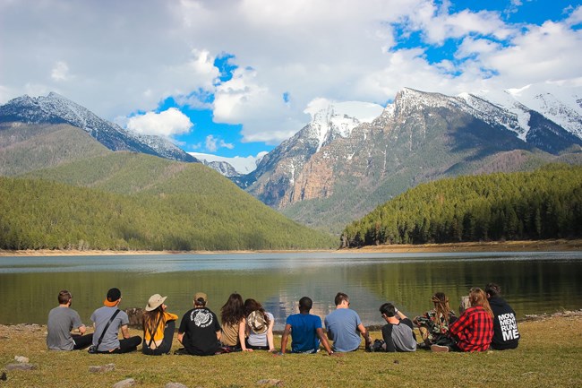 Group of young adults enjoying the view of a mountain range.