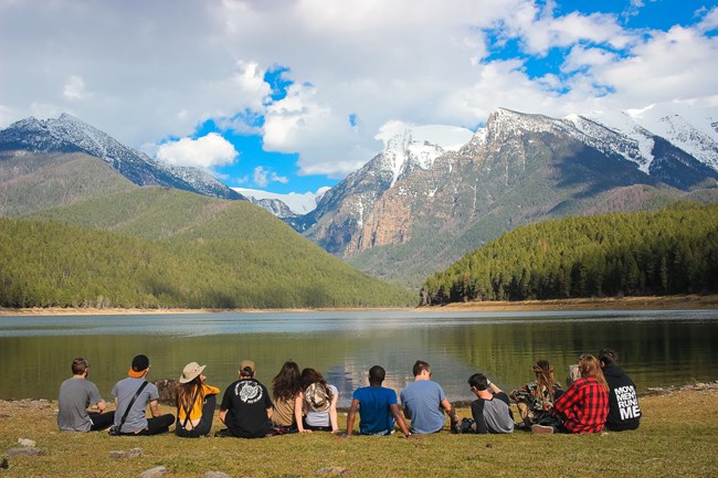 What We Do Group of young adults enjoying the view of a mountain range.