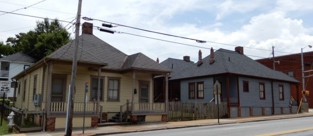 Historic duplex shotgun houses One brown house and one blue house next to a power line