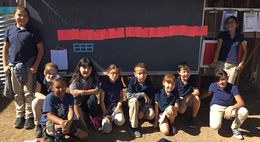 A group of school children with a banner that says 'biodiversity'