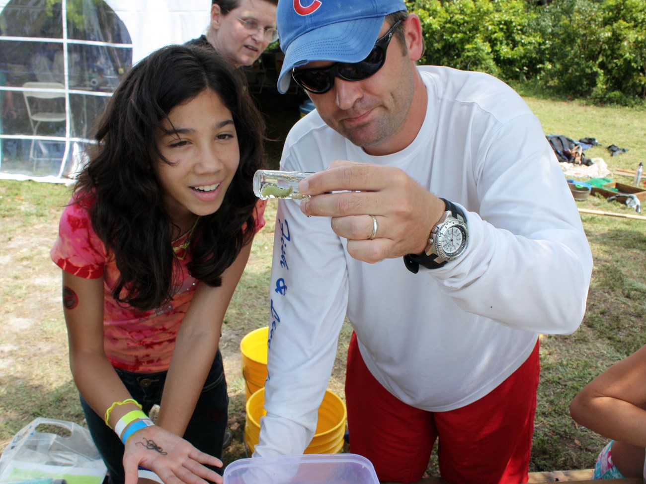 Young girl and a scientist examine a organism in a test tube