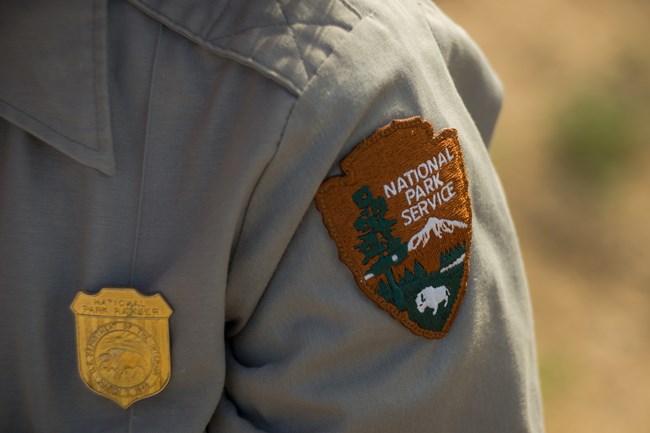 Closeup of the arrowhead badge on a park ranger's uniform