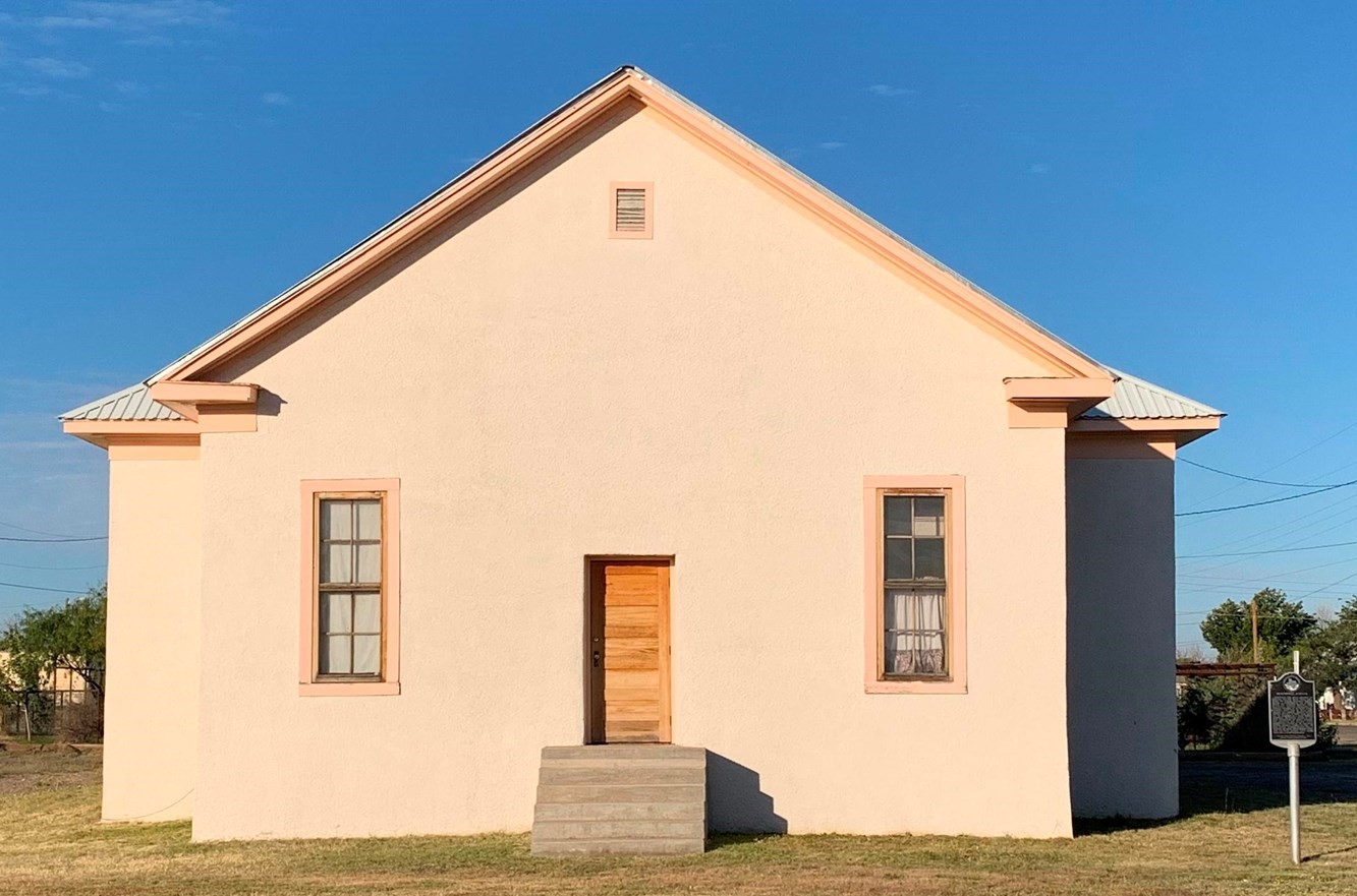 Photo of Balckwell School shows a small tan building with a center door and a window on each side.