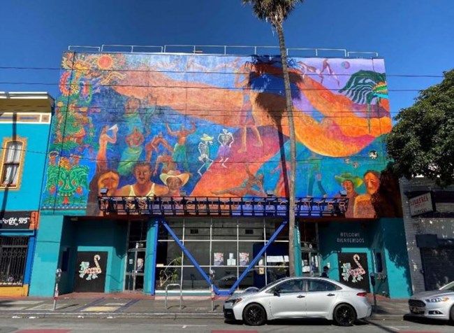 A two story building with a large, colorful mural.