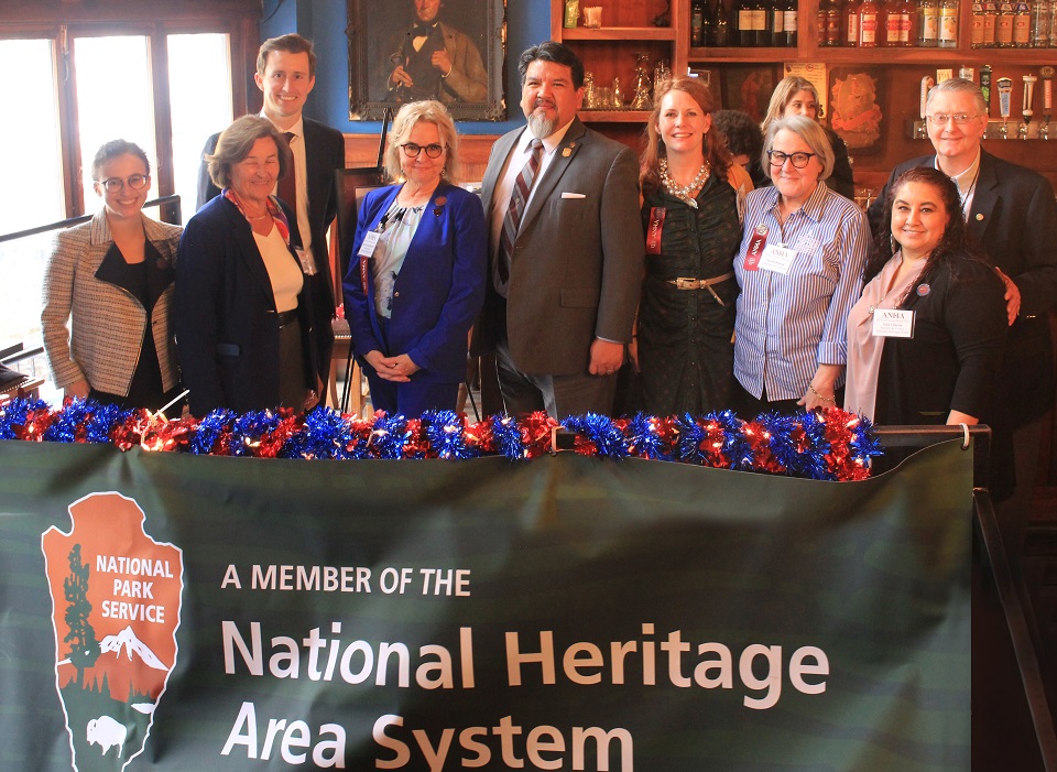 Alliance of National Heritage Areas Conference Nine people stand in front of an organization banner.