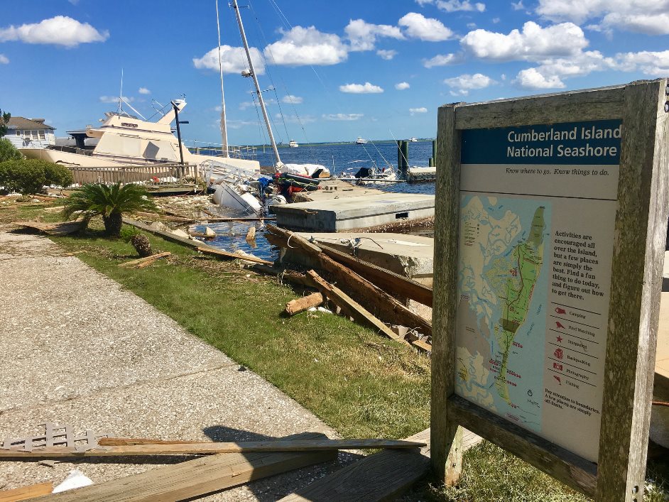 Cumberland Island National Seashore after Hurricane Irma park sign, debris, and a boat along the seashore