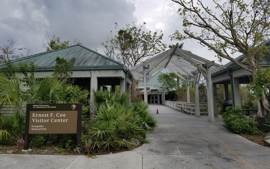 tree-lined walkway leading to the front door of a visitor center