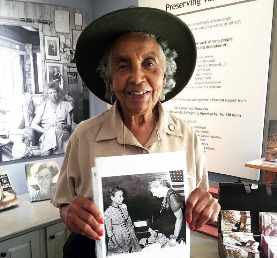 Volunteer guide Doris Mack holding a photograph of her with Eleanor Roosevelt taken in 1958